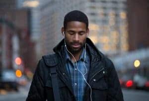 Young african american man walking with headphones in while zoning out | online therapy for anxiety treatment for teens & adults | Synergy eTherapy