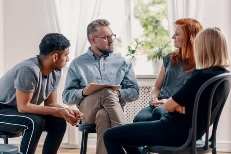 counselor talking to his patients during treatment in an office