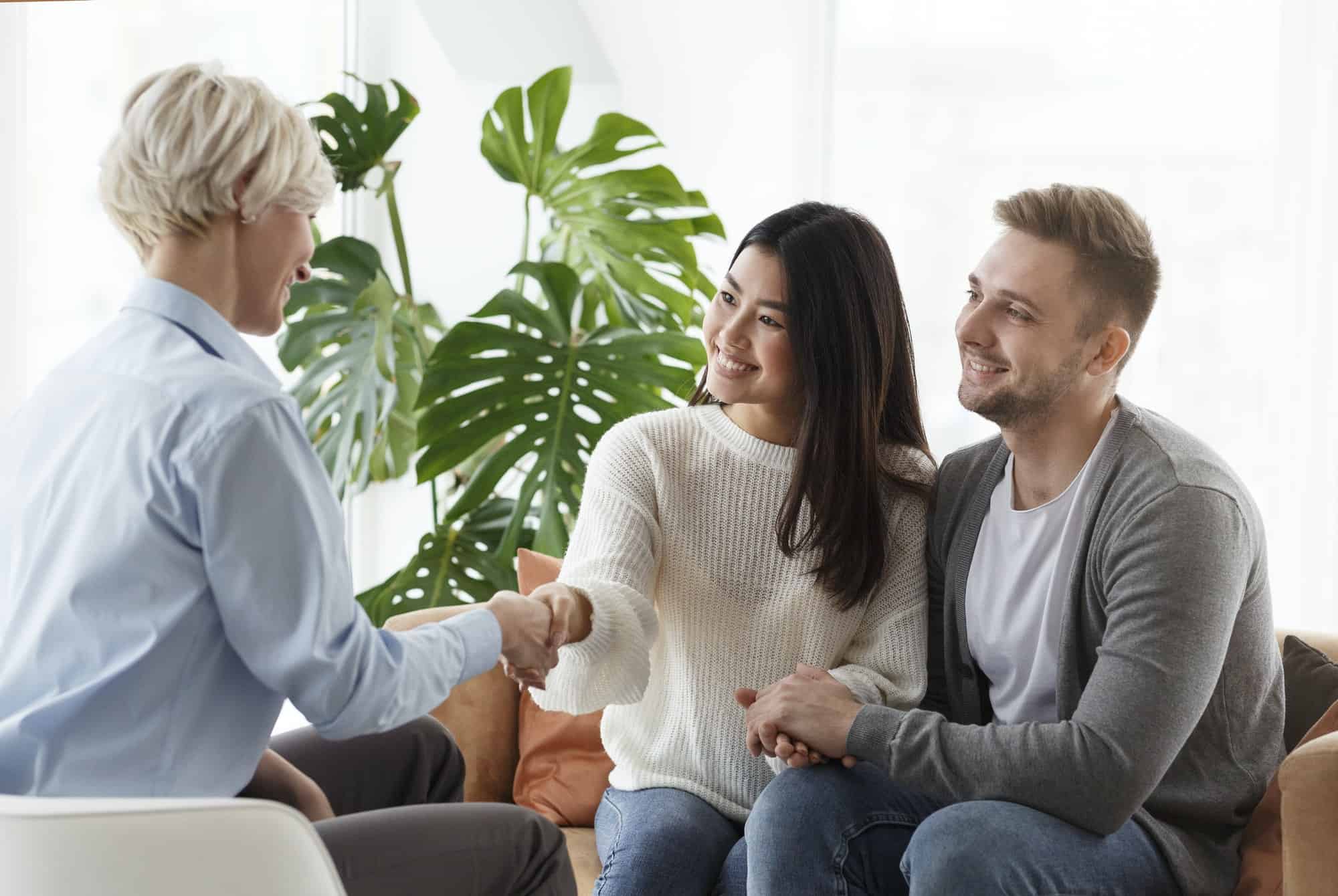 couple shaking hands with counselor thankful for help in office 1